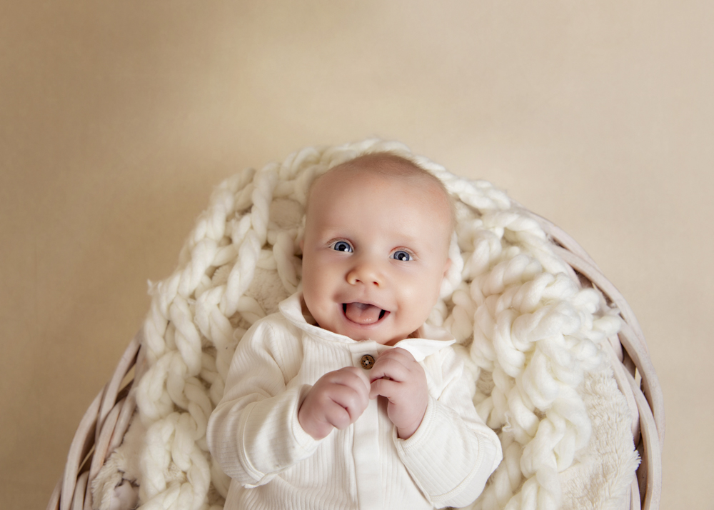 Older baby on cozy White knitted blanket