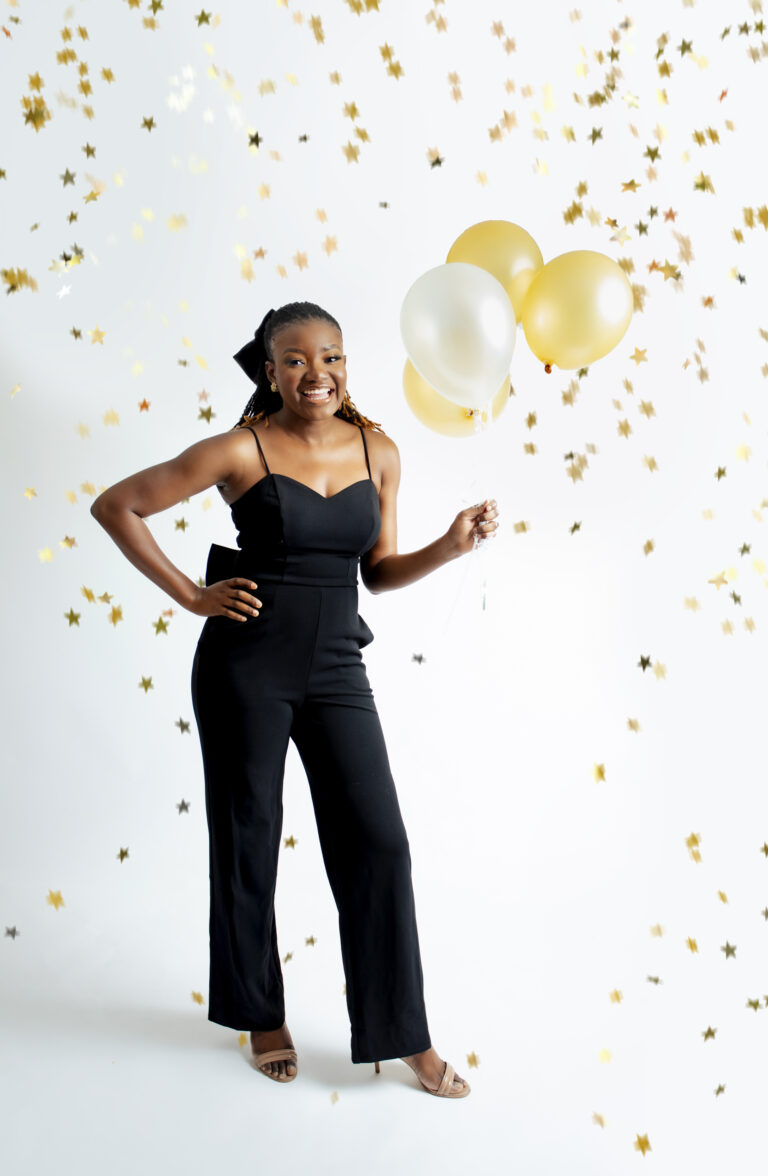 African birthday woman holding balloons looking excited