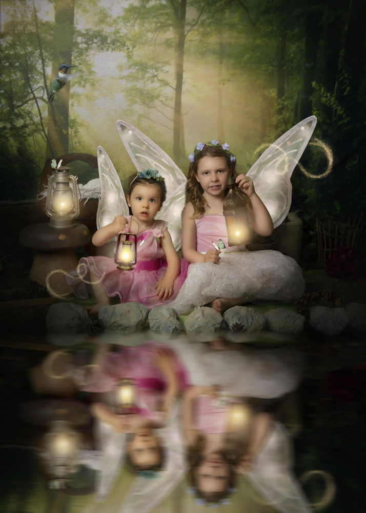Sisters snuggled up for a fairytale photosession holding enchanted lanterns