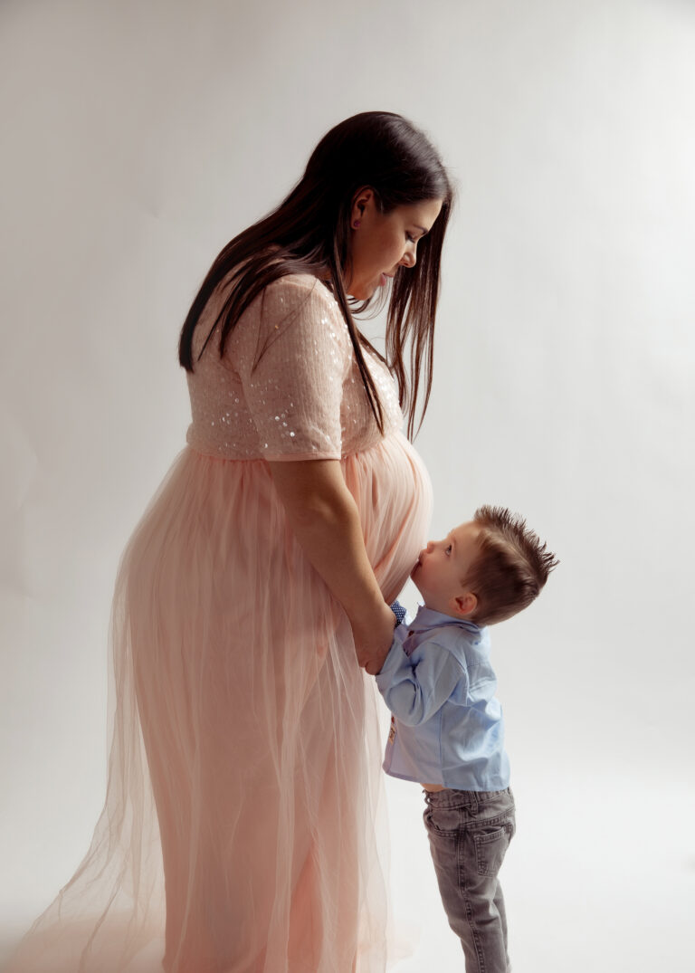 Mom that is pregnant with a baby boy kissing her belly