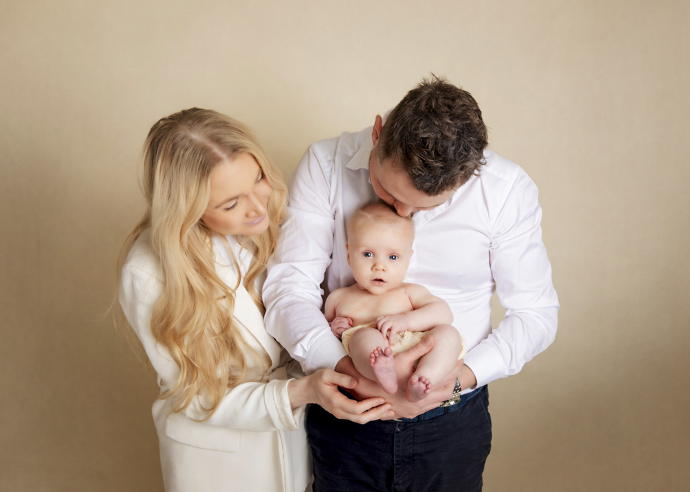 Older baby Photographer in studio held lovingly by parents